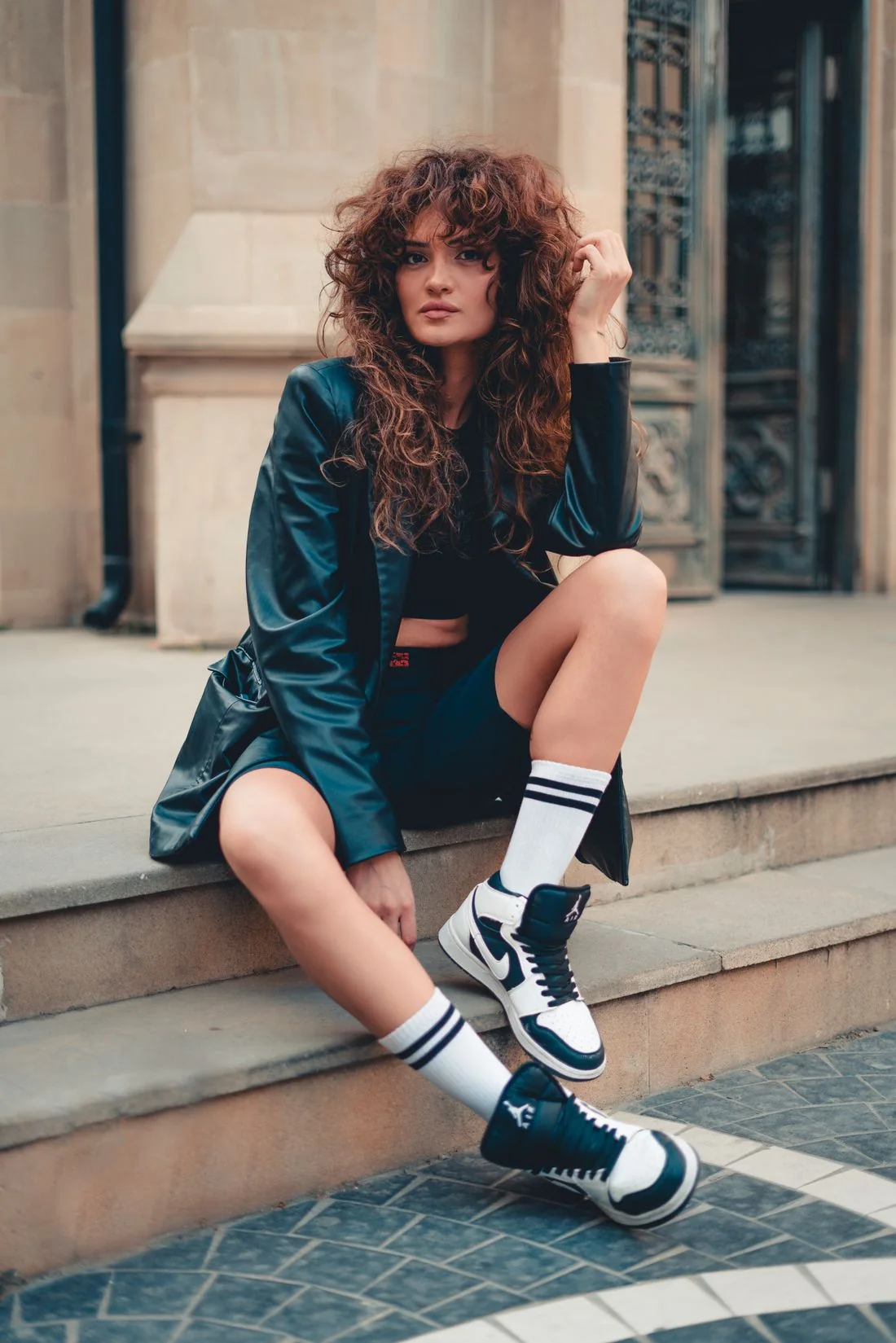 A woman in dark lace-up shoes seated on stone steps.