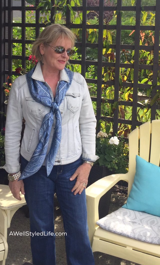 Pale washed denim jacket and deep blue jeans are pulled together by a scarf