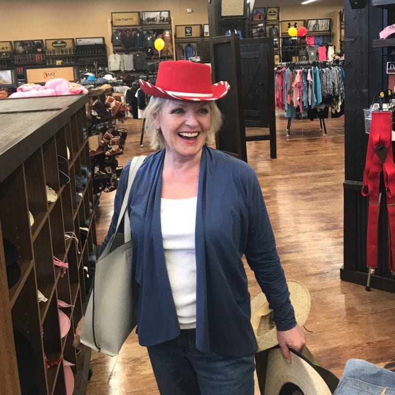 Jennifer Connolly of A Well Styled Life trying on cowboy hats