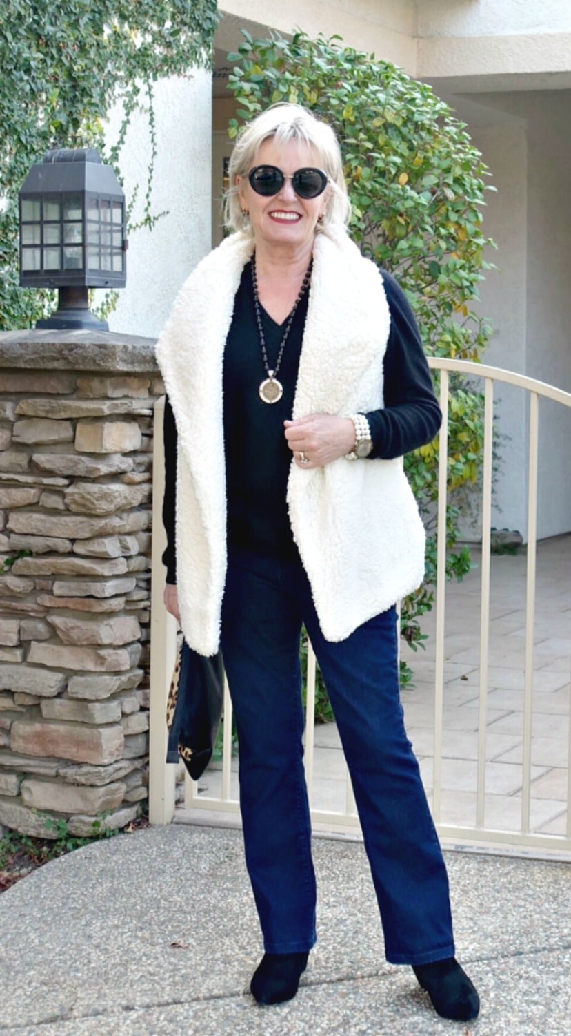 Jennifer Connolly of A well styled life wearing boot cut jeans and fleece vest with black pointed toe booties