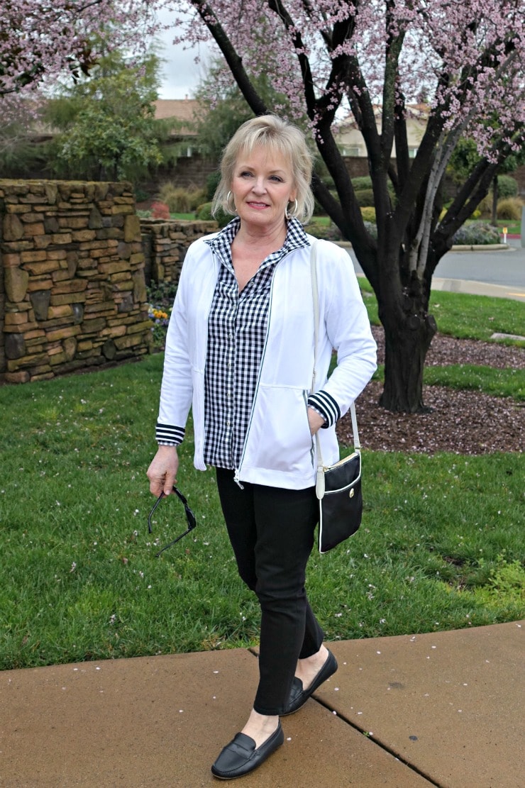 Jennifer Connolly of A Well Styled Life wearing black and white gingham shirt, black never fade jeans, black driving moccasins and white T Talbots yoga jacket from Talbots