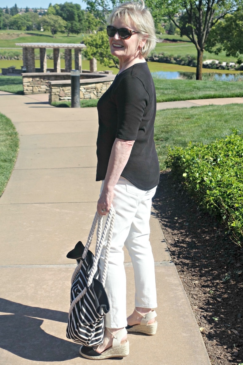 casual tee outfit of cream jeans, black tee, black espadrilles and striped tote on A Well Styled Life