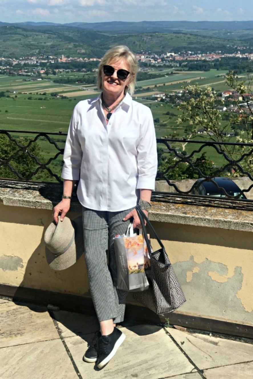Jennifer Connolly of A Well Styled Life wearing Chico's no iron white shirt on balcony of an abbey