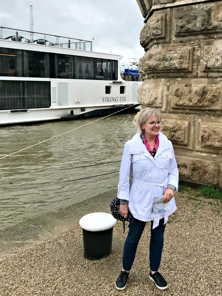 Style blogger Jennifer Connolly of A Well Styled Life next to her Viking River Boat wearing white jacket and Jag jeans