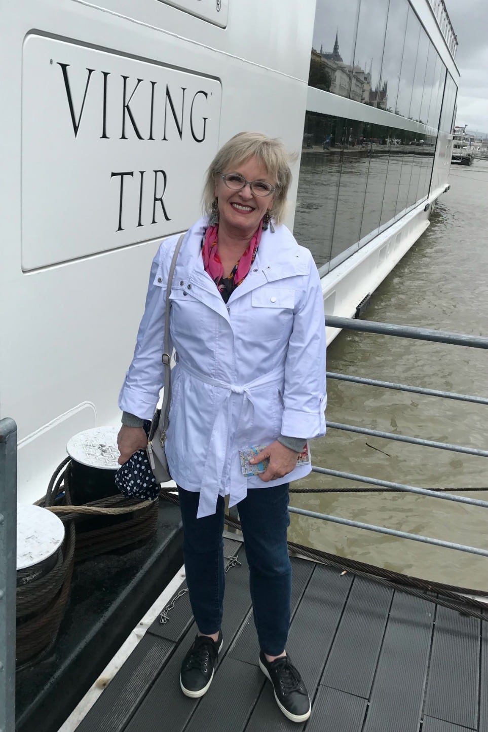 Jennifer Connolly of A Well Styled Life wearing white jacket and blue jeans boarding a Viking ship in Bucharest