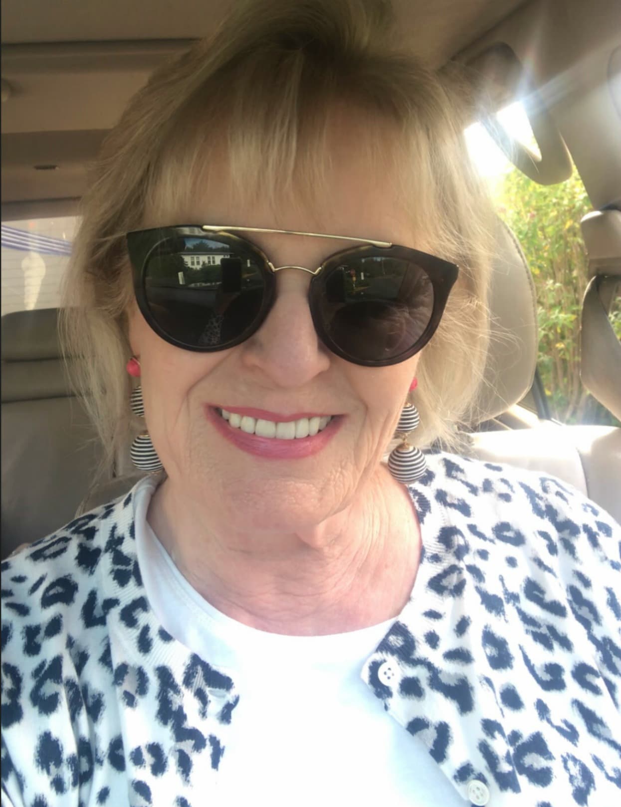 Jennifer Connolly of A Well Styled Life wearing leopard cardigan from Banana Republic and stiped pom-pom earrings from Target