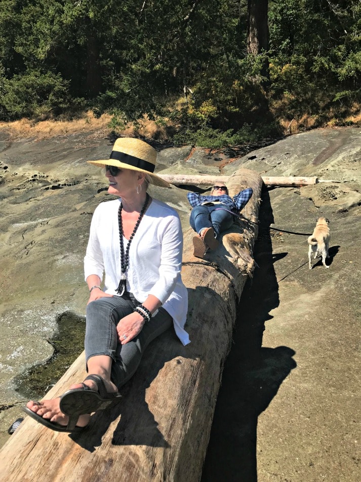 Jennifer Connolly of A Well Styled Life wearing a straw fedora with white and black outfit on beach on Gabriola Island