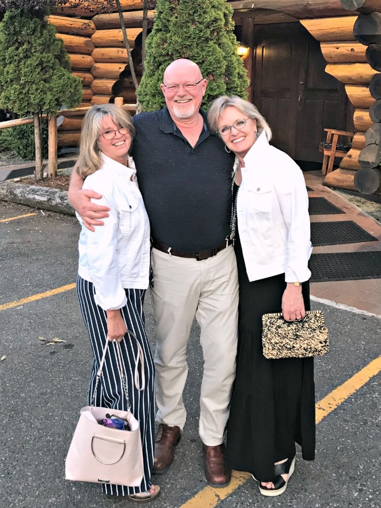 Jennifer Connolly of A Well Styled Life wearing a black maxi dress with white denim jacket
