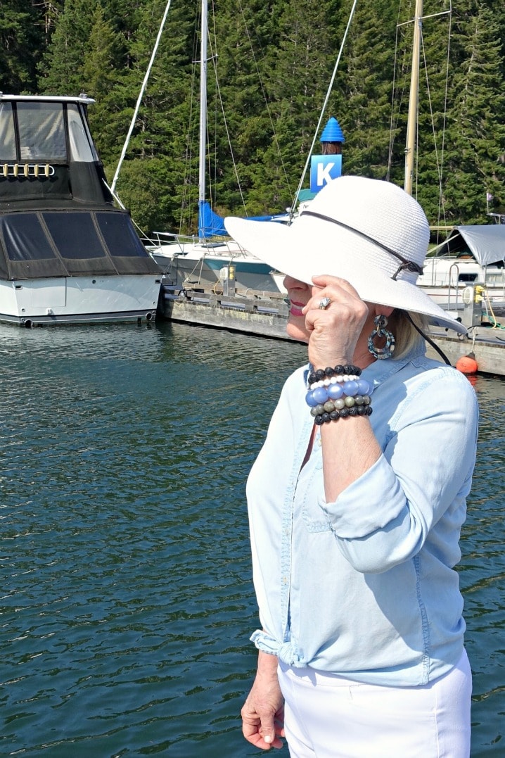 Jennifer Connolly of A Well Styled Life wearing packable white sunhat, denim shirt and white shorts