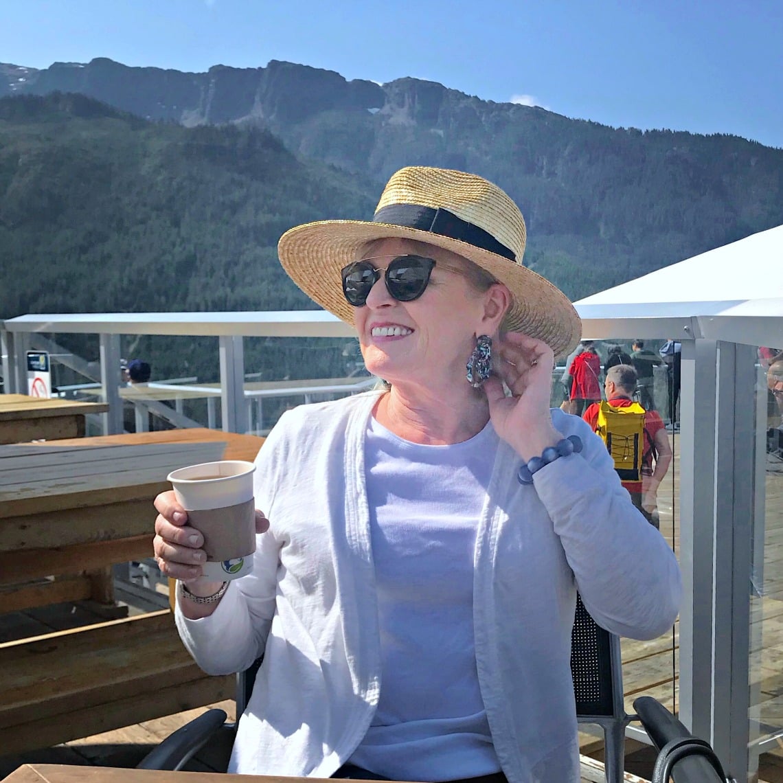 Jennifer Connolly of A Well Styled life wearing a casual outfit with straw hat, white cardigan and white tank top