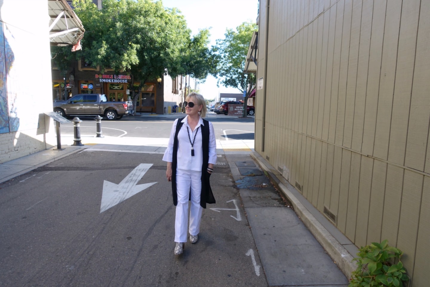 Jennifer Connolly of a Well Styled Life wearing a long black vest as a third piece over a column of white