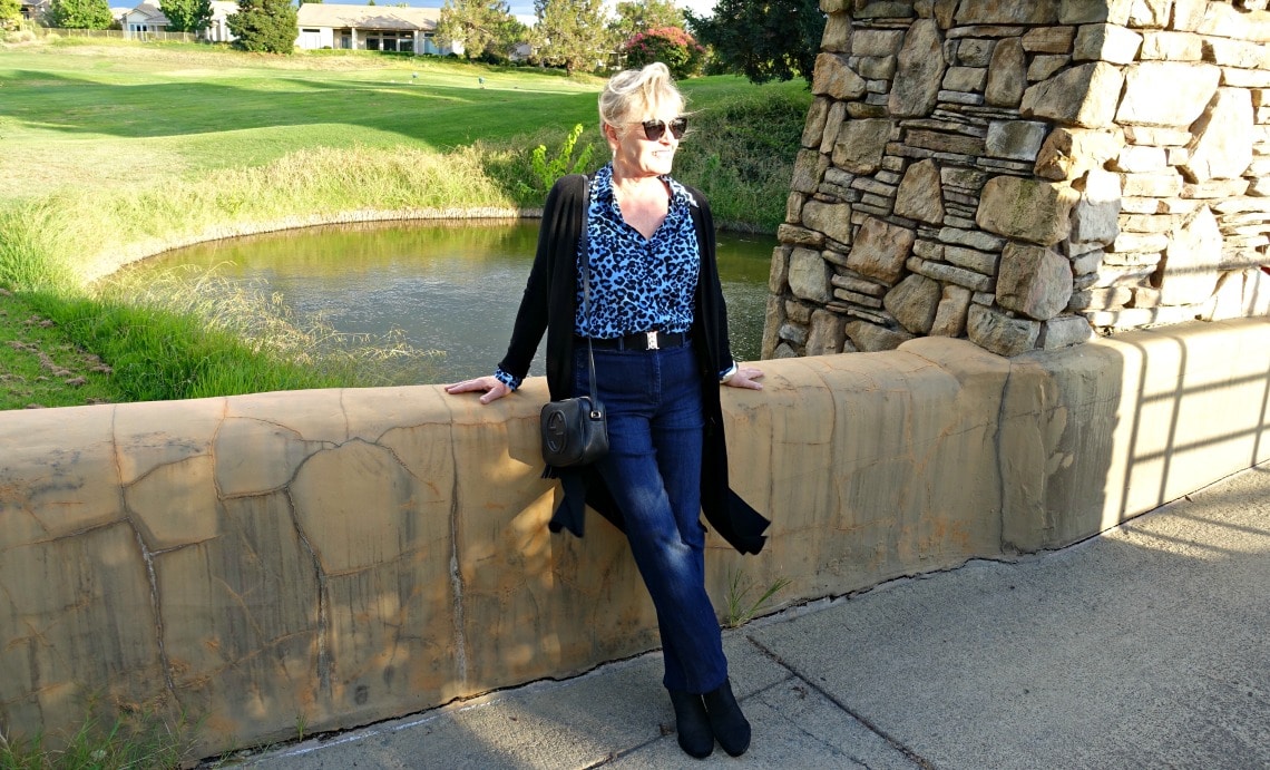 Jennifer Connolly of A Well Styled Life wearing blue leopard shirt from Banana Republic with denim trousers and black duster
