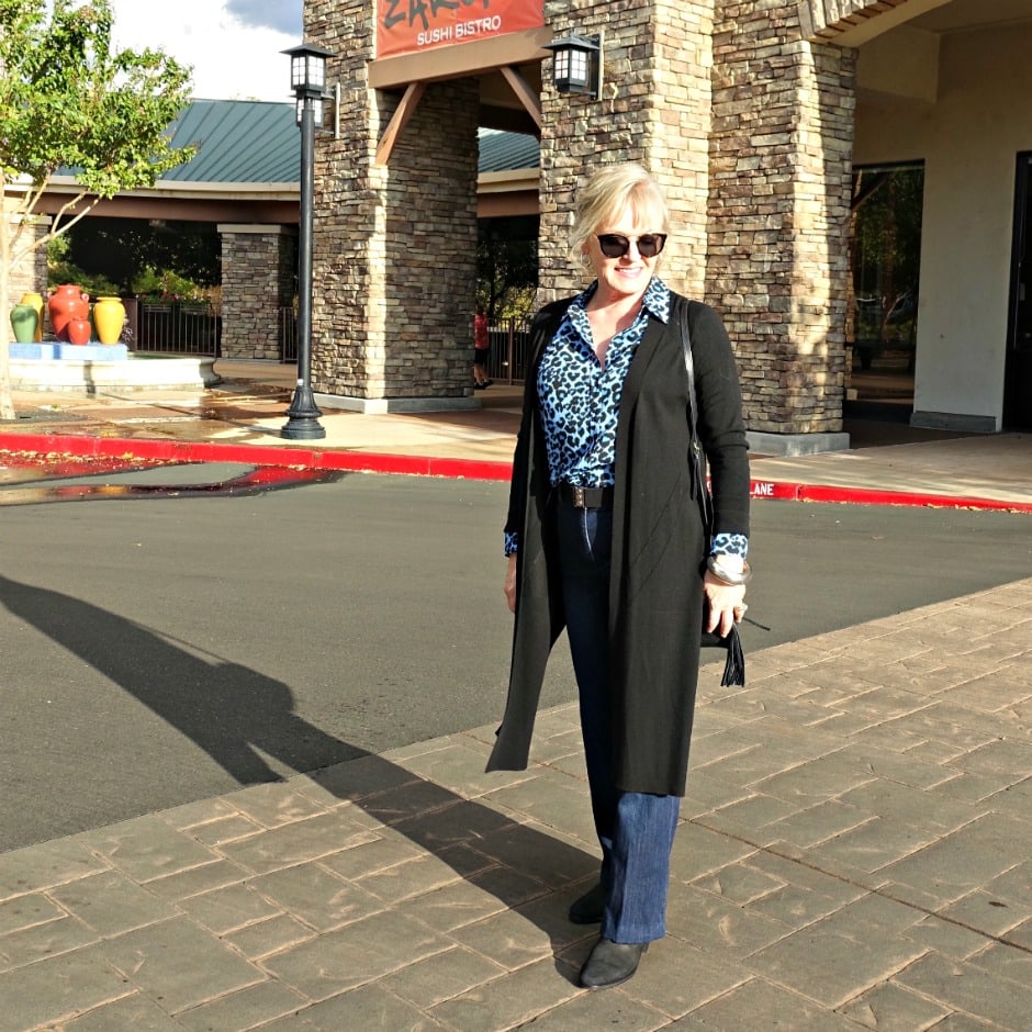 Jennifer Connolly of A Well Styled Life wearing casual outfit of leopard shirt, blue jeans and black booties