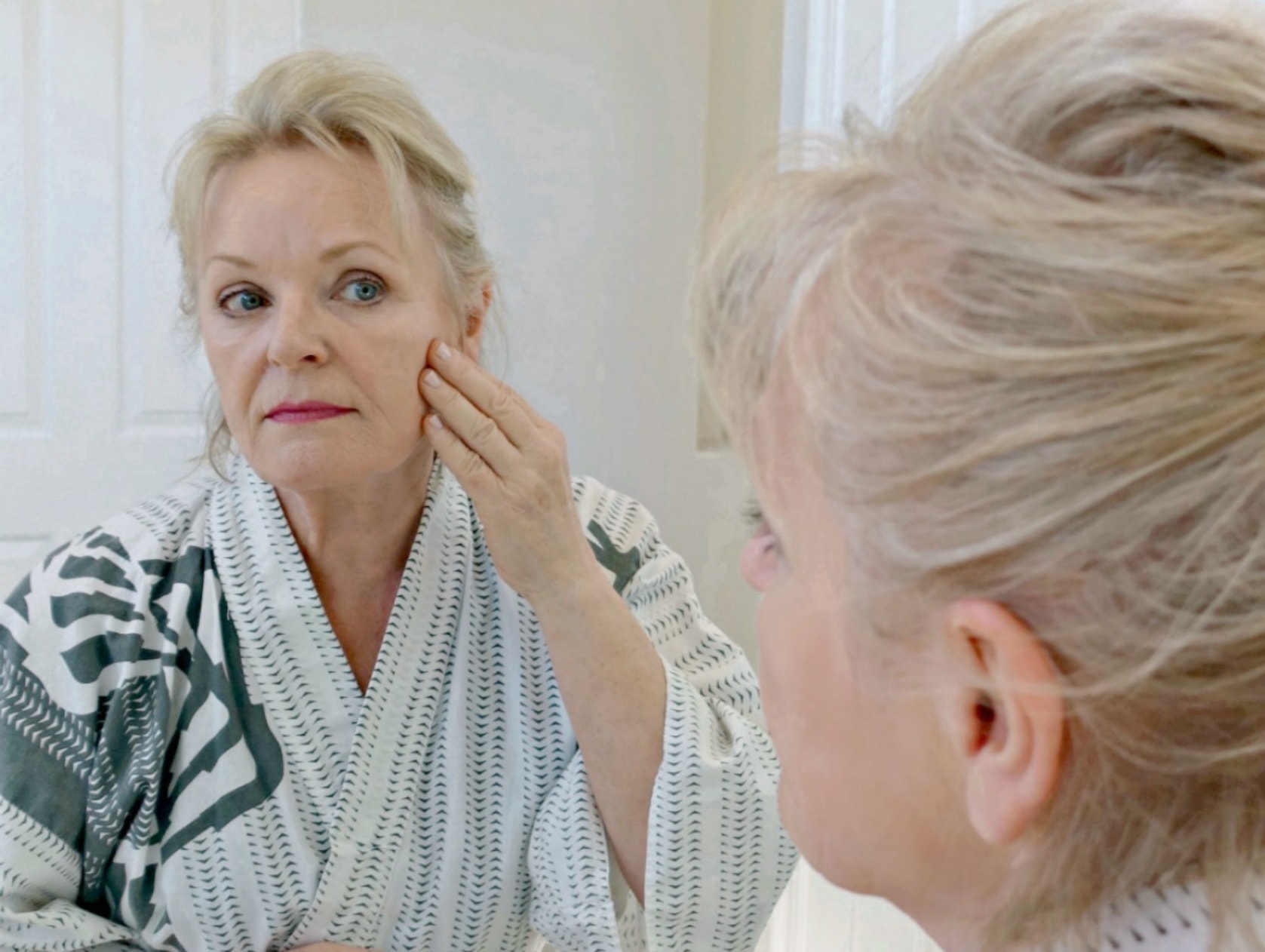 Jennifer Connolly of A Well Styled Life looking at complexion in mirror