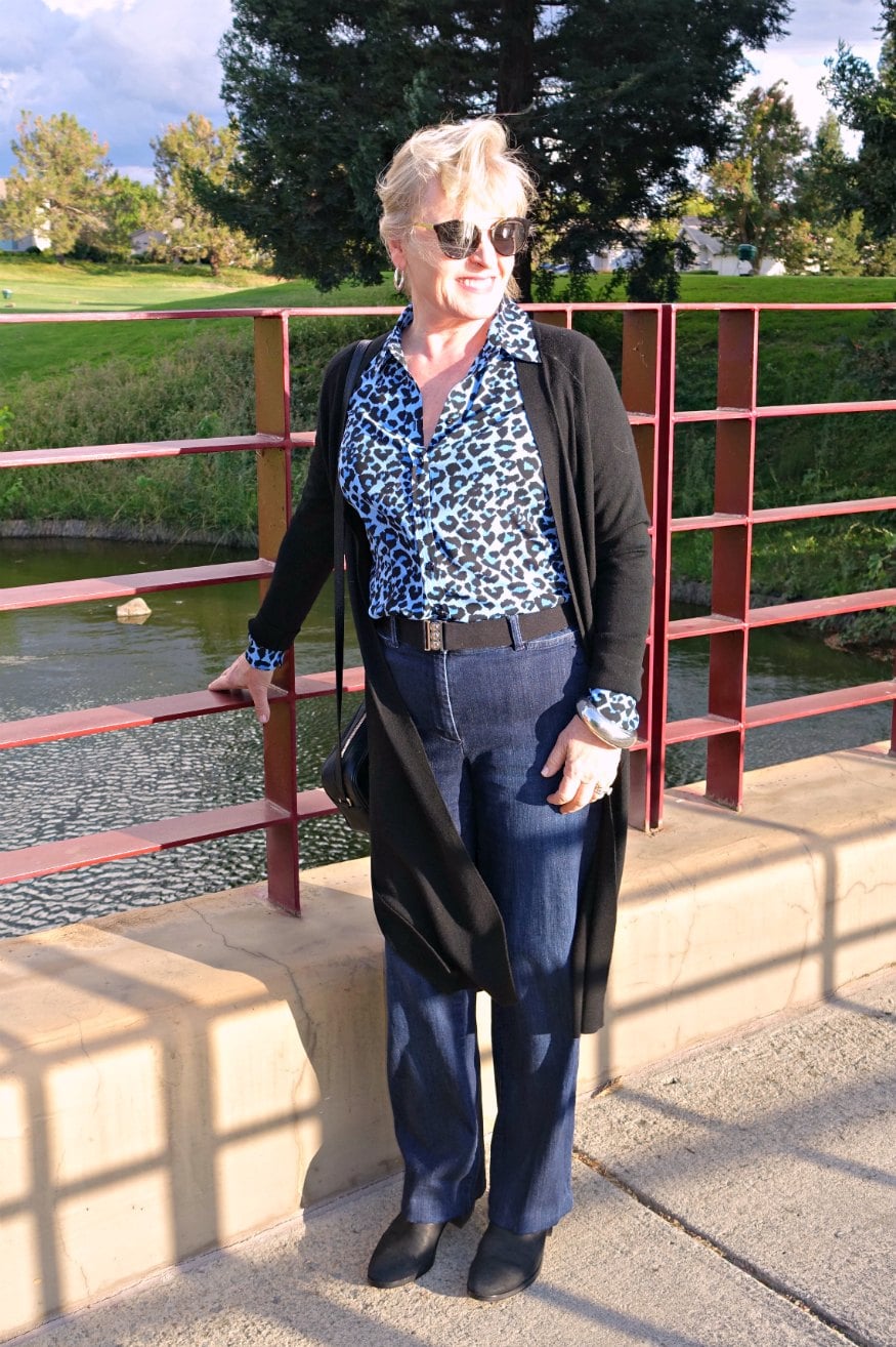 Jennifer Connolly of A Well Styled Life wearing blue jeans with leopard shirt and black sweater