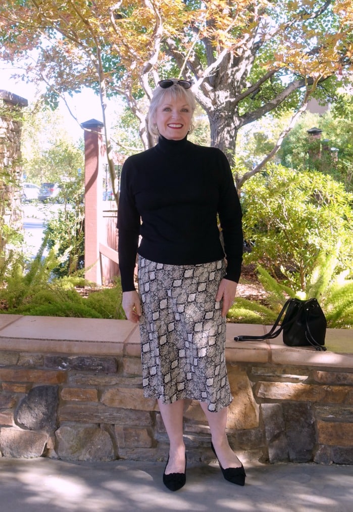 Jennifer Connolly of A Well Styled Life wearing a midi skirt and black turtleneck