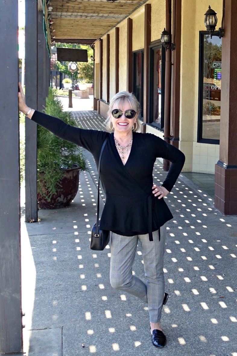 Jennifer Connolly of A Well Styled Life wearing comfortable stretch pants and black sweater on sidewalk