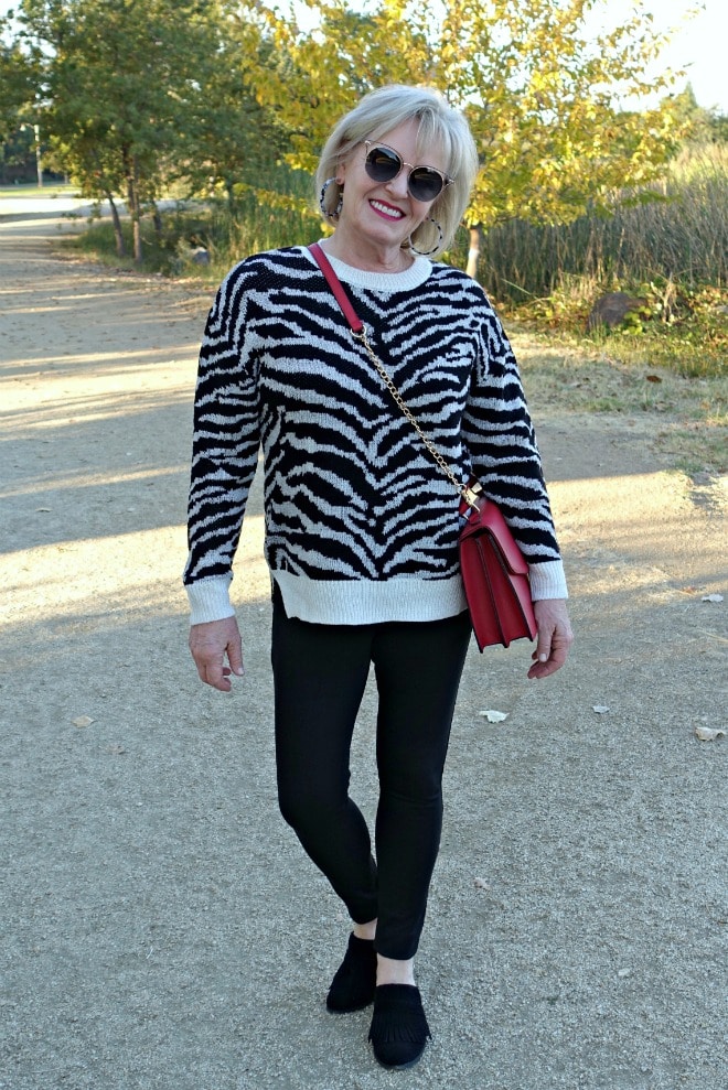 Jennifer Connolly of A Well Styled Life wearing zebra sweater with black jeans and mules