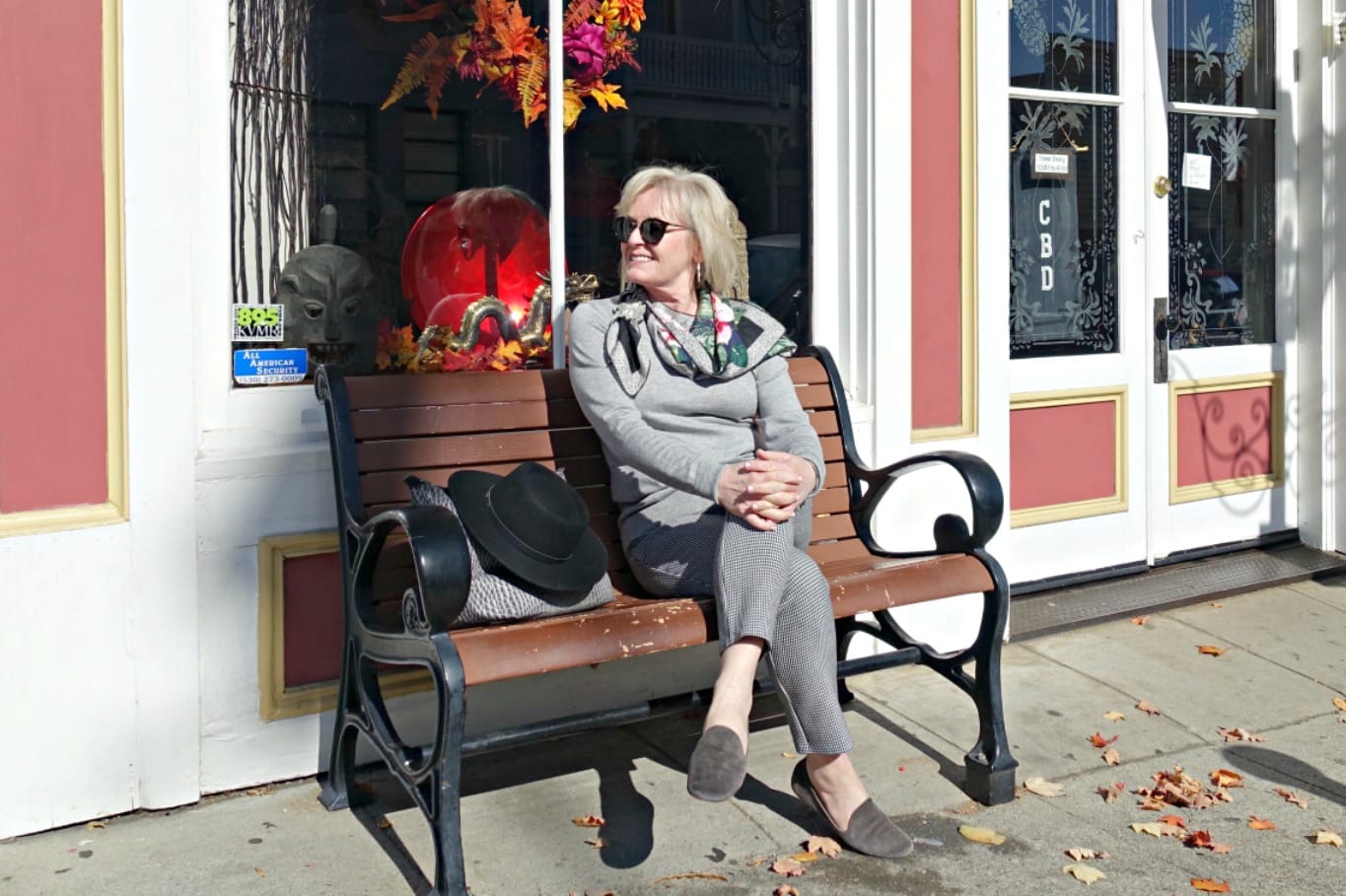 Jennifer Connolly of A Well Styled Life sitting on bench wearing gray head to toe