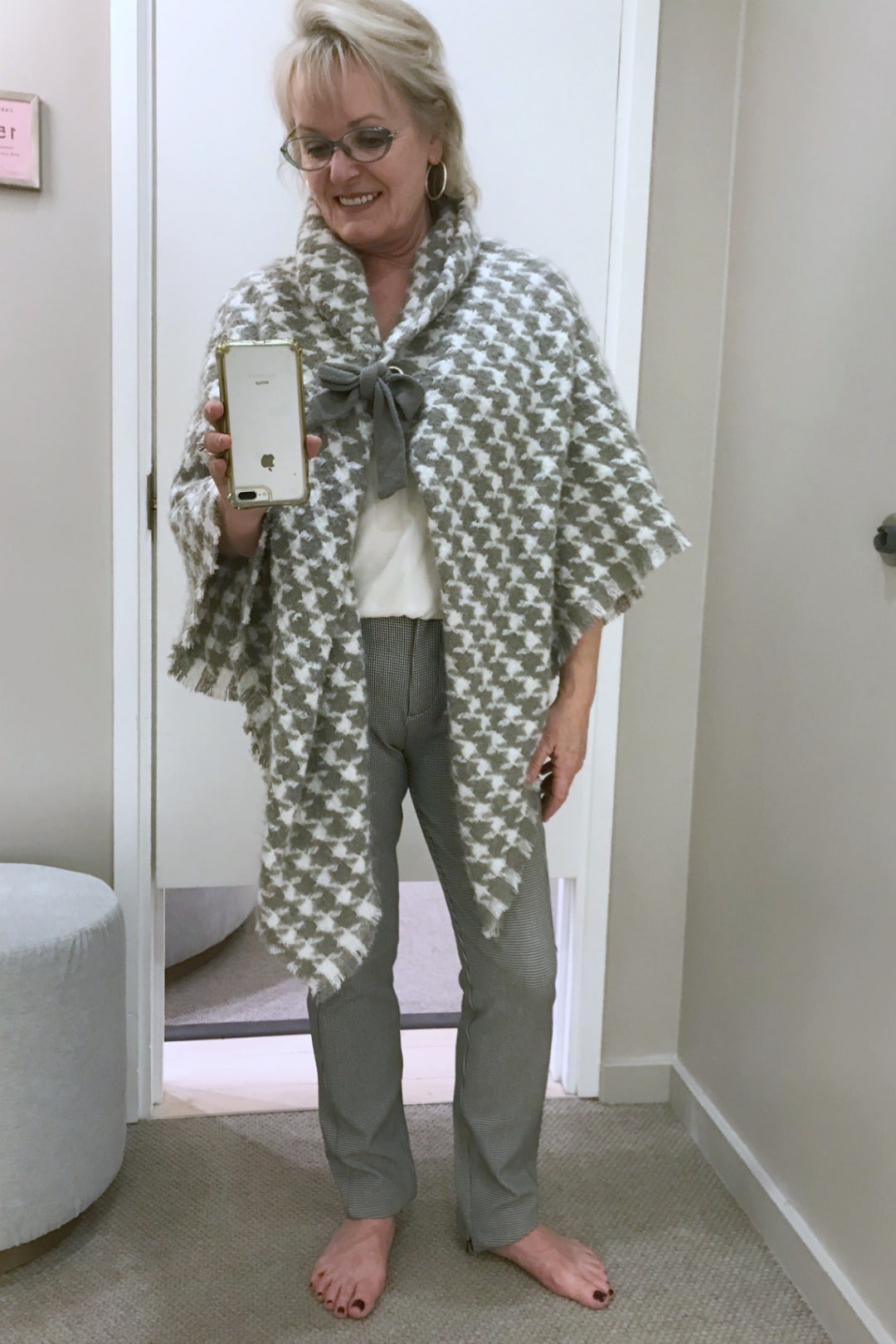 Jennifer Connolly in Ann Tyalor dressing room trying on plaid poncho and tweed leggings