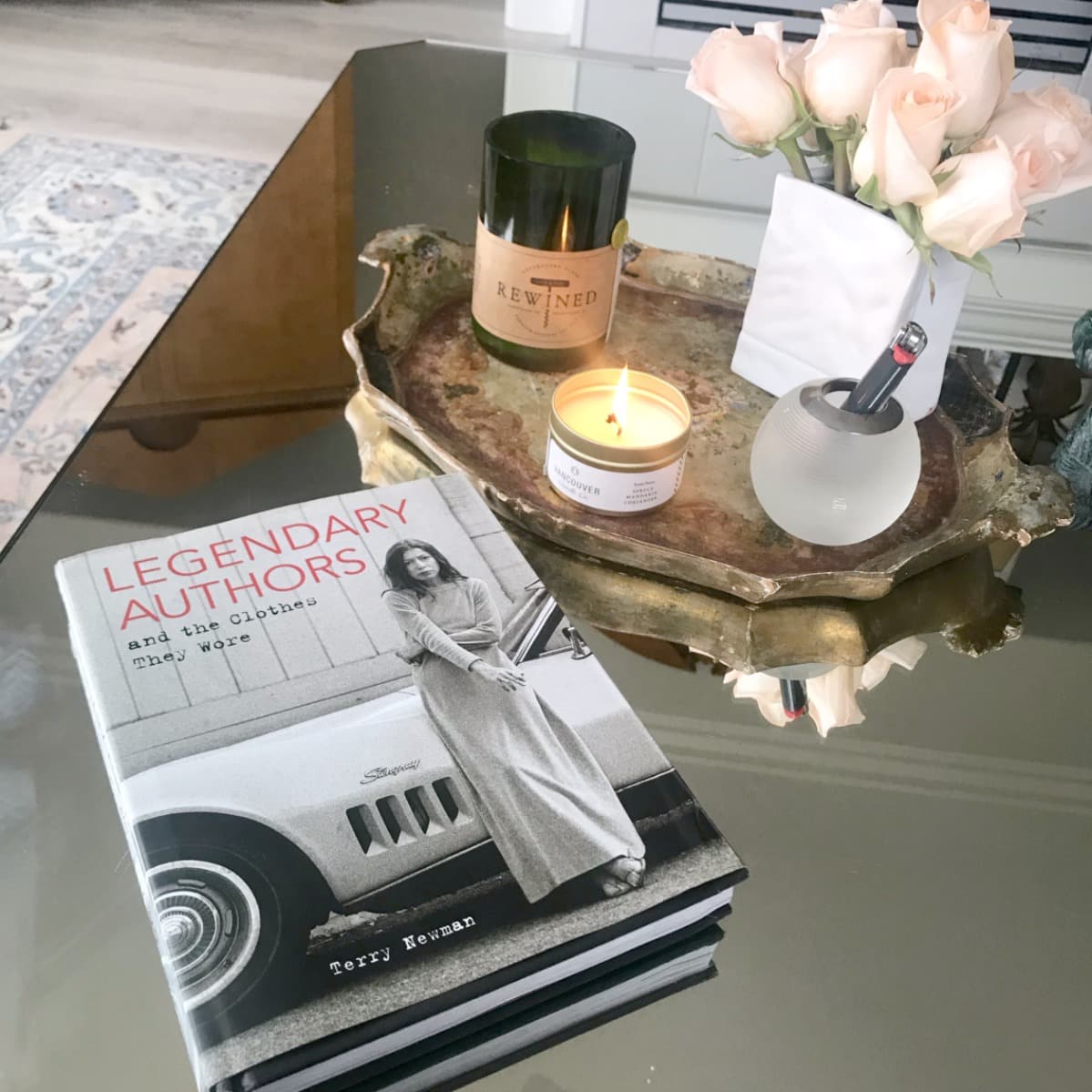 book and several candles on mirrored coffee table