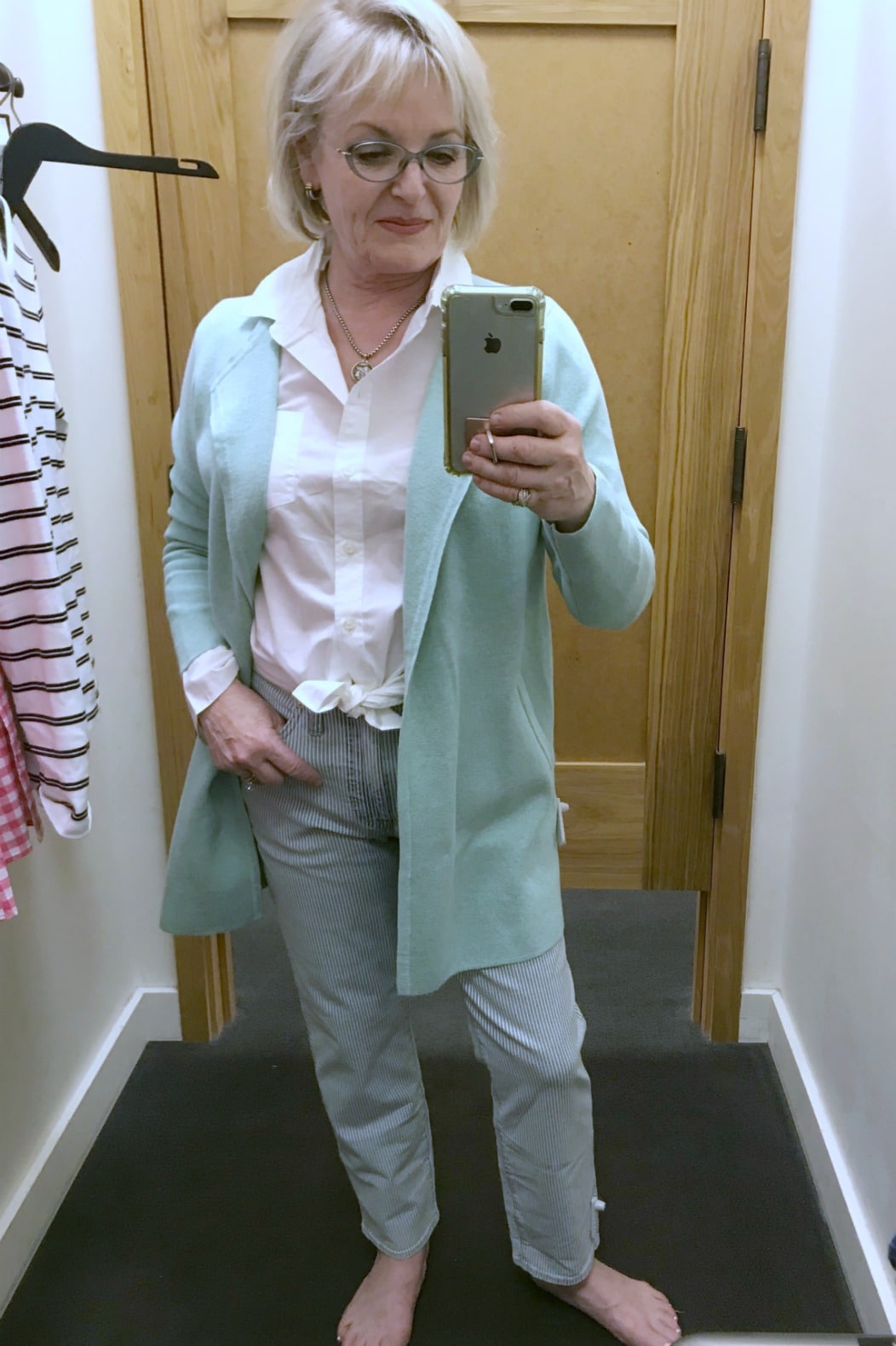 Jennifer Connolly of A Well Styled life wearing mint sweater blazer over white shirt and striped jeans