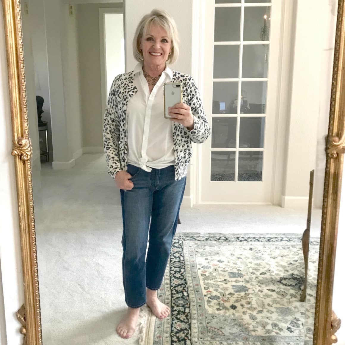 Jennifer Connolly of A Well Styled Life wearing leopard cardigan with white shirt and blue jeans