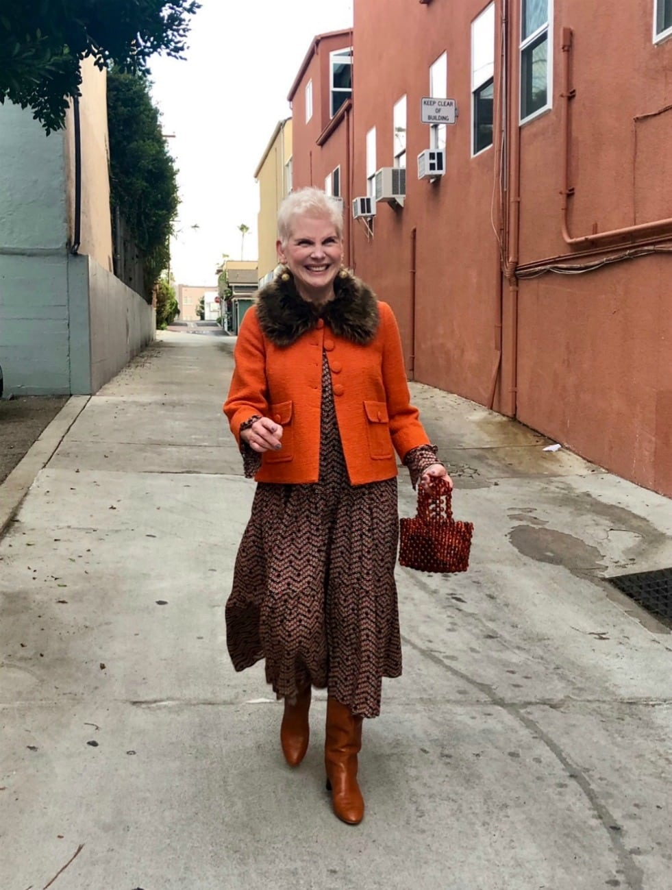 woman in brown skirt and orange jacket