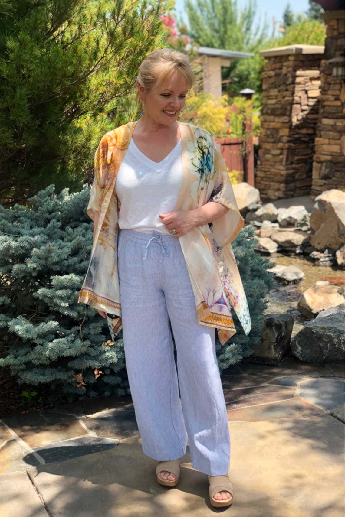 over 50 fashion blogger Jennifer Connolly wearing striped linen pants and silk ruana
