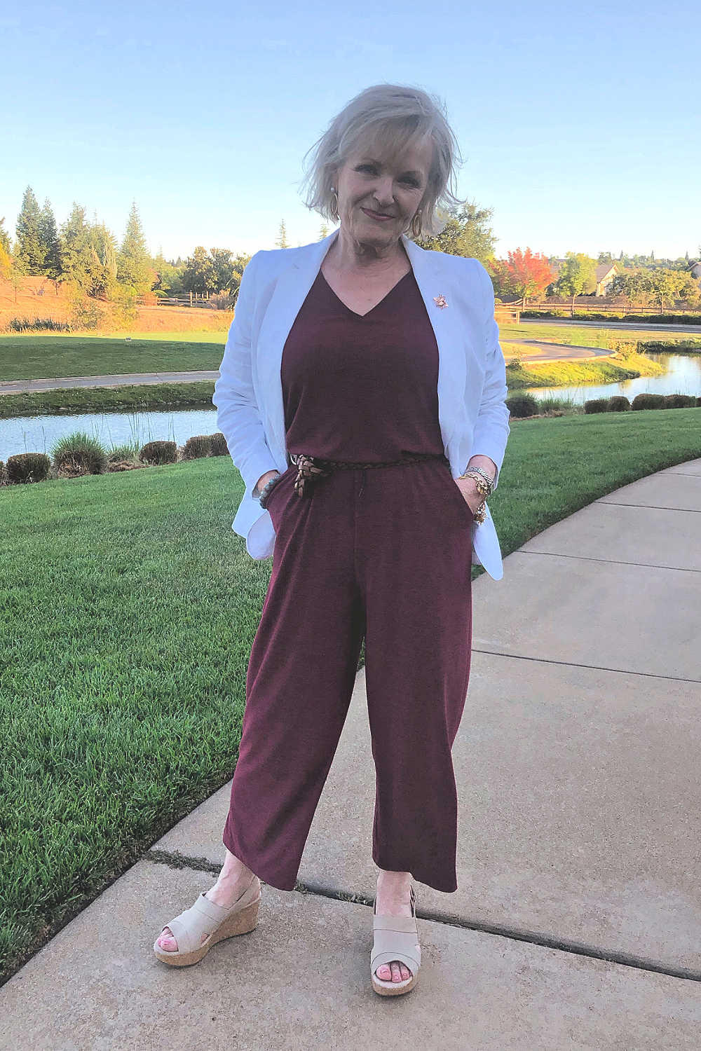 fashion blogger jennifer Connolly wearing white linen blazer over athleisure jumpsuiut