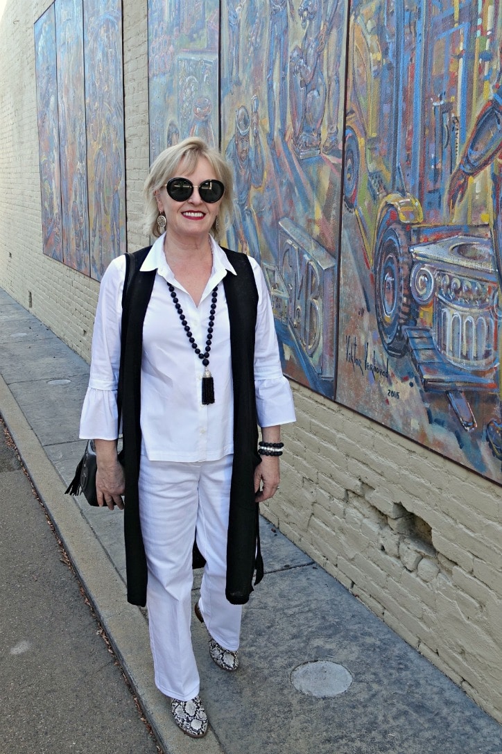 WOMAN WALKING IN BLACK VEST, WHITE SHIRT AND WHITE JEAN