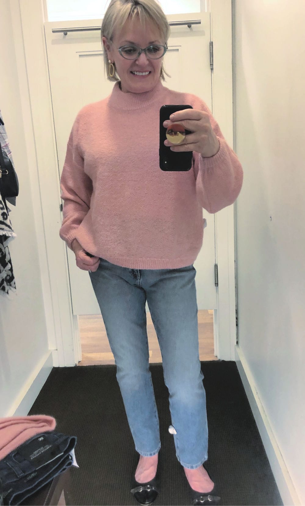 fashion blogger jennifer connolly wearing pink sweater and pale wash blue jeans