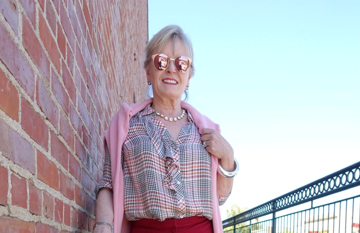 jennifer of A Well Styled Life wearing plaid shirt, red pants and rose gold sunglasses