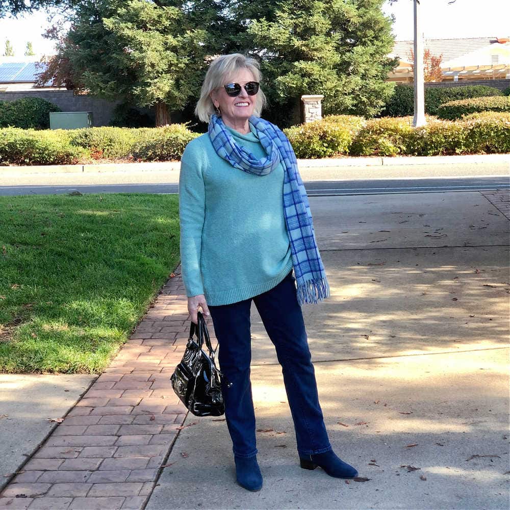 over 50 fashion blogger jennifer connolly of a well styled life wearing blue jeans, plaid scarf and aqua sweater