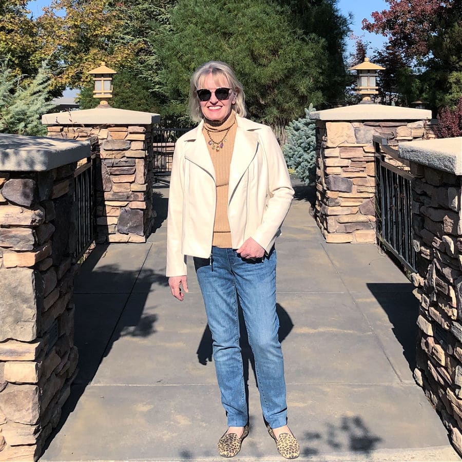 over 50 fashion blogger wearing faux leather jacket, jeans and leopard flats