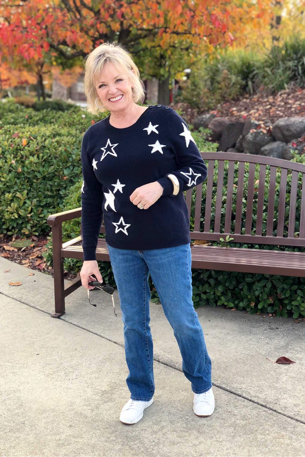 fashion blogger jennifer of a well styled life wearing navy sweater and blue jeans with white sneaker