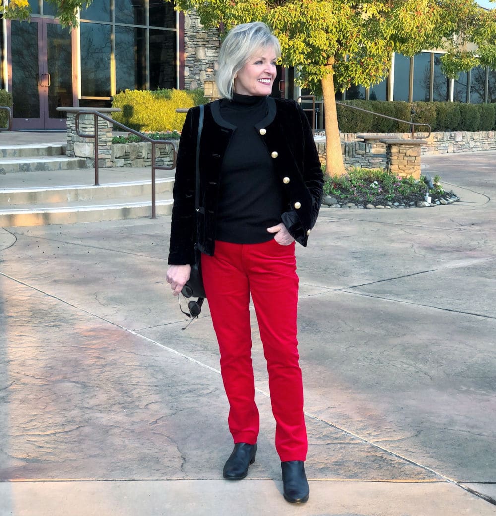 fashion blogger jennifer connolly of a well styled life modeling black jaket over red pants