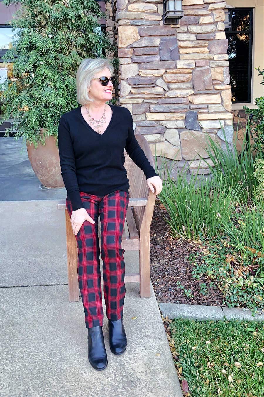 fashion blogger jennifer of a well styled life wearing everlane black sweater with red and black check pants from j jill
