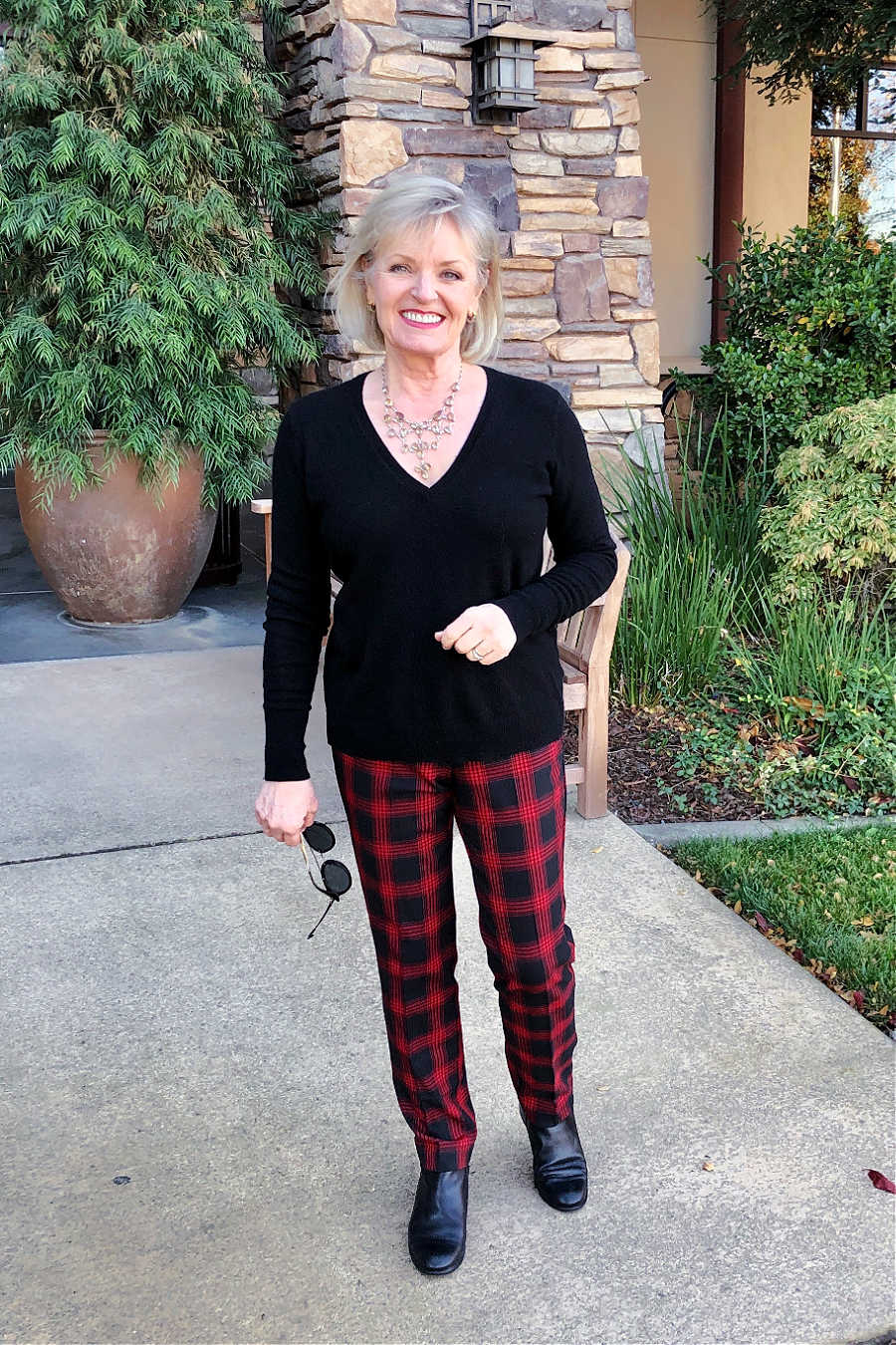 over 50 fashion blogger jennifer connolly of a well styled life wearing everlane black sweater with red and black checked pants from j jill
