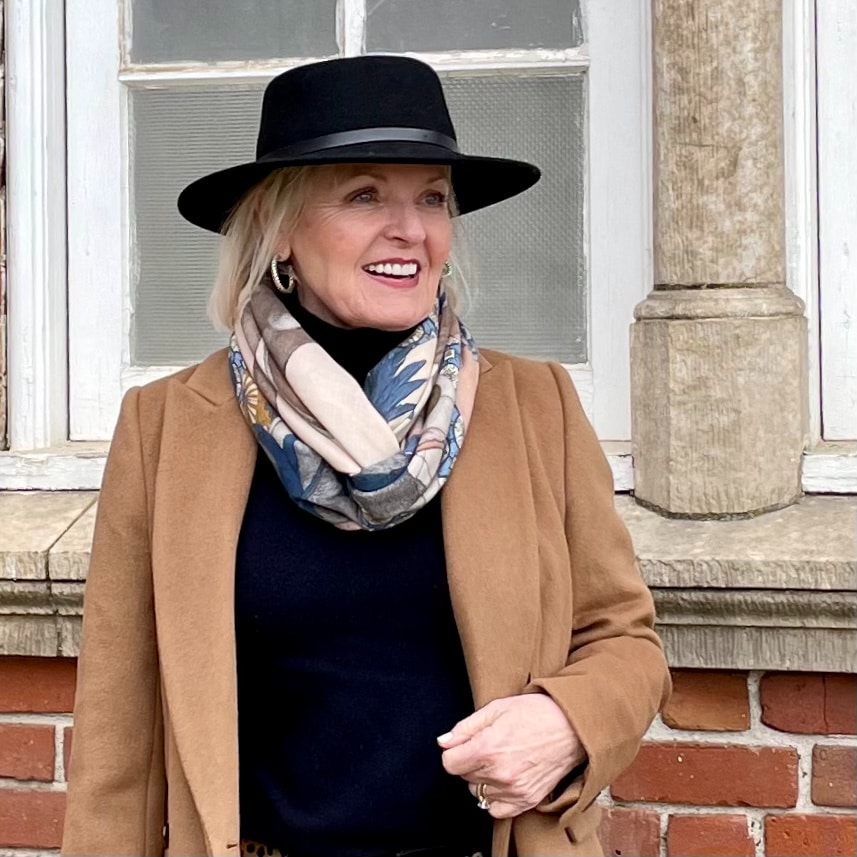 woman in black hat with scarf and camel coat