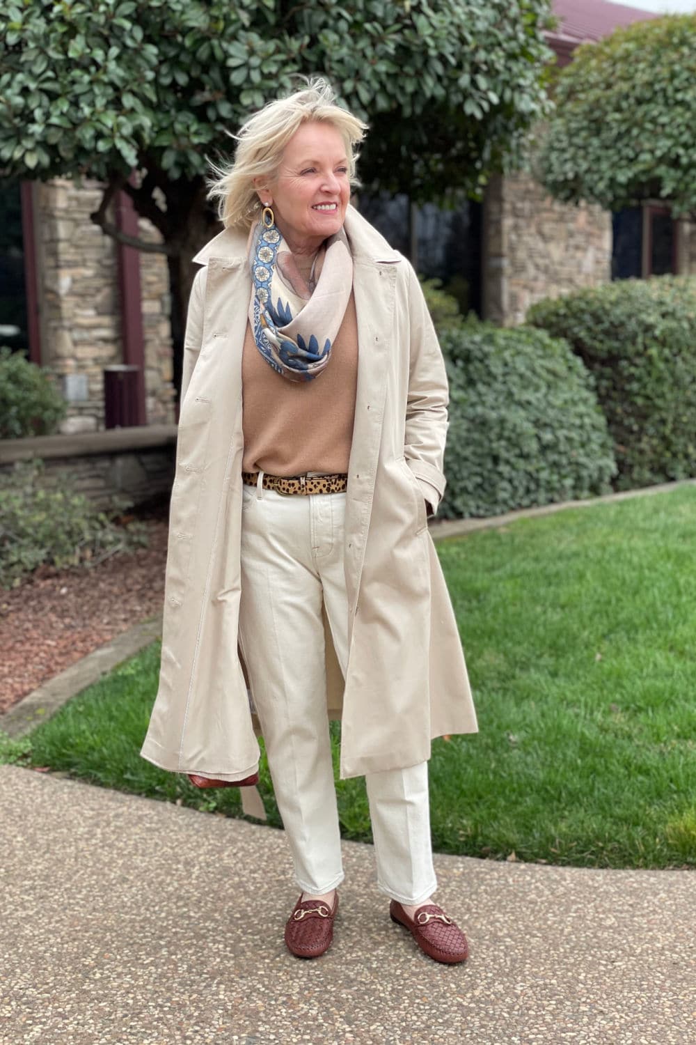 jennifer of a well styled life wearing loft swing trench coat over camel colored sweater and ivory jeans