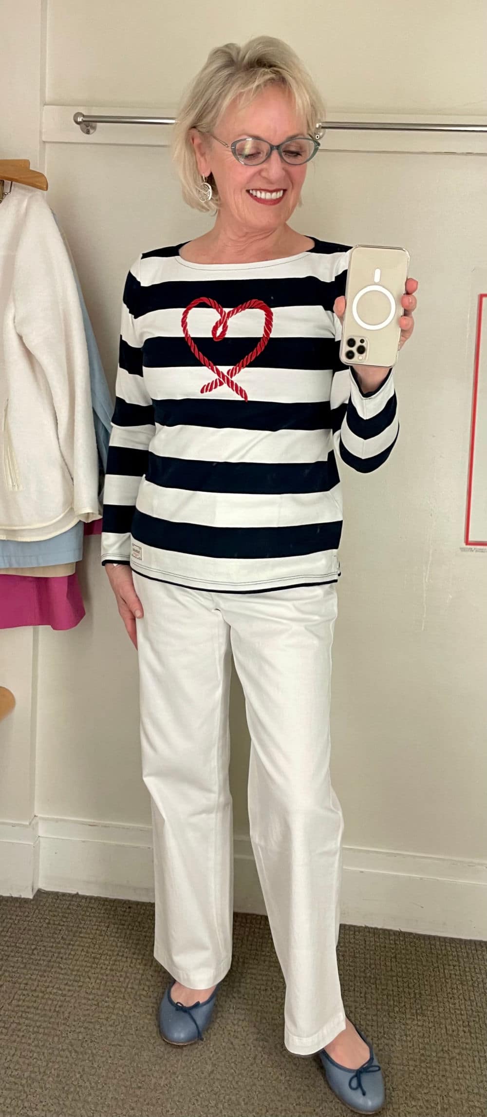 blonde woman modeling striped tee in dressing room