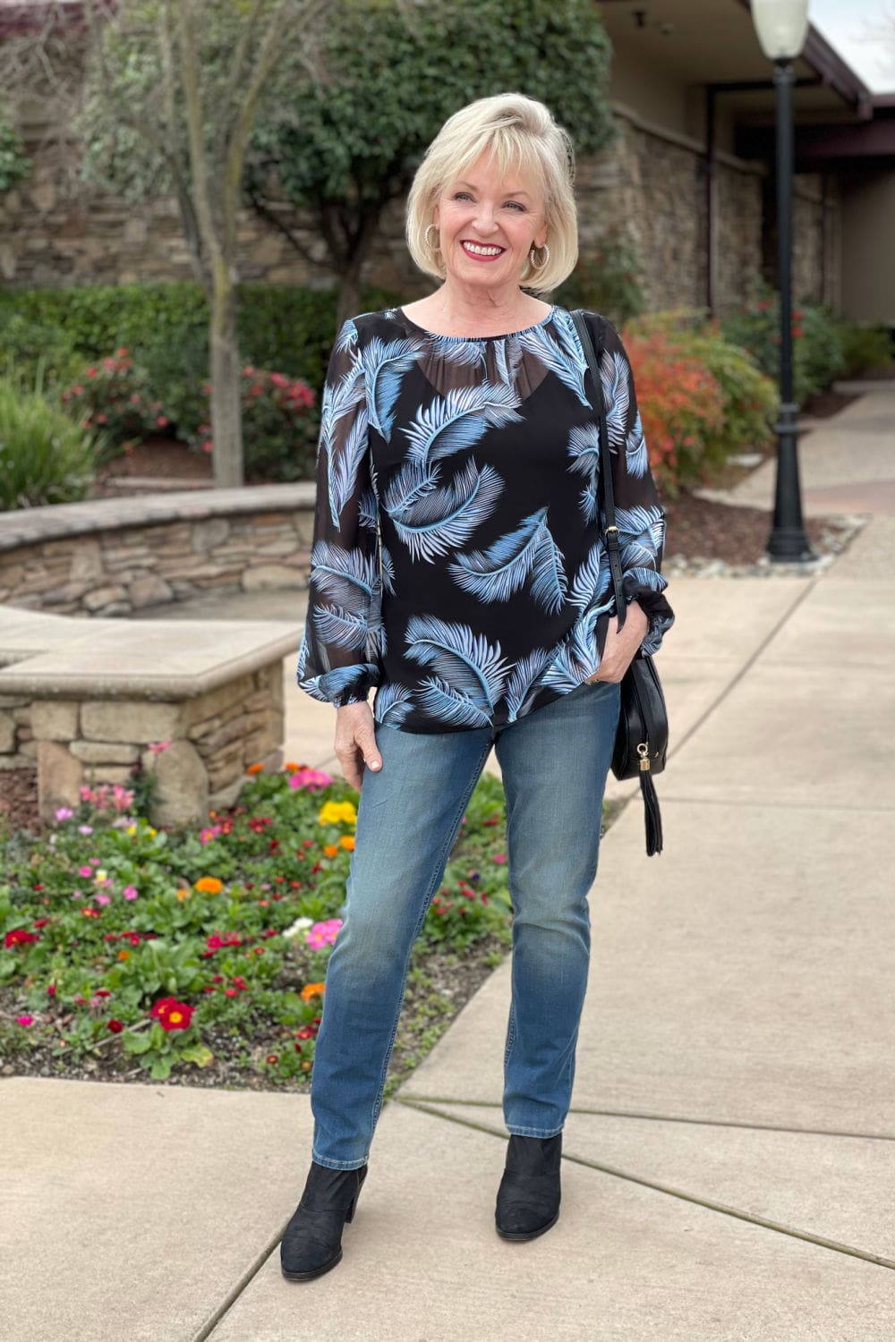 woman wearing slim jeans with blue see through top and cami
