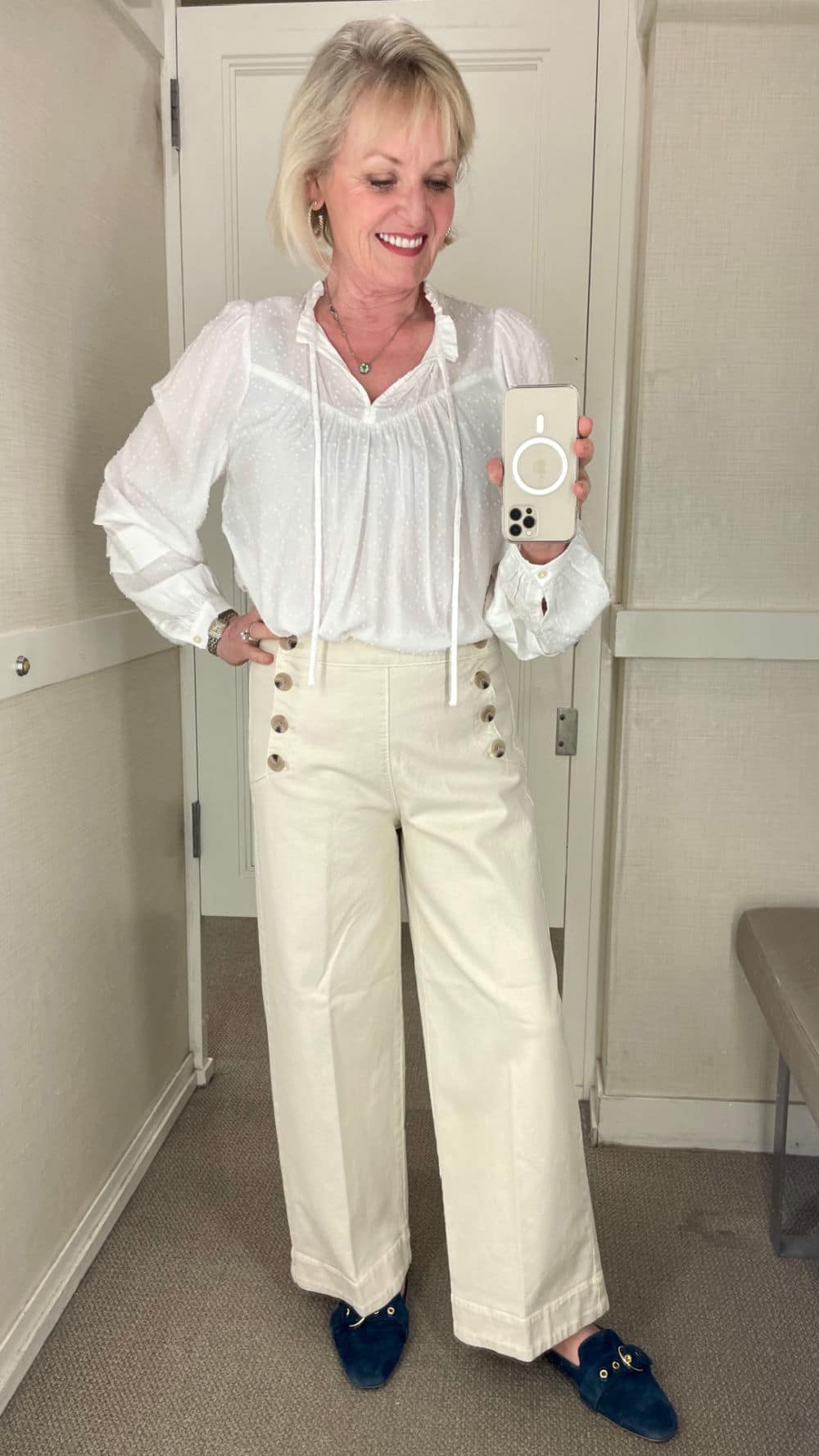 over 50 fashion blogger wearing sailor wide-leg pants and white blouse in dressing room