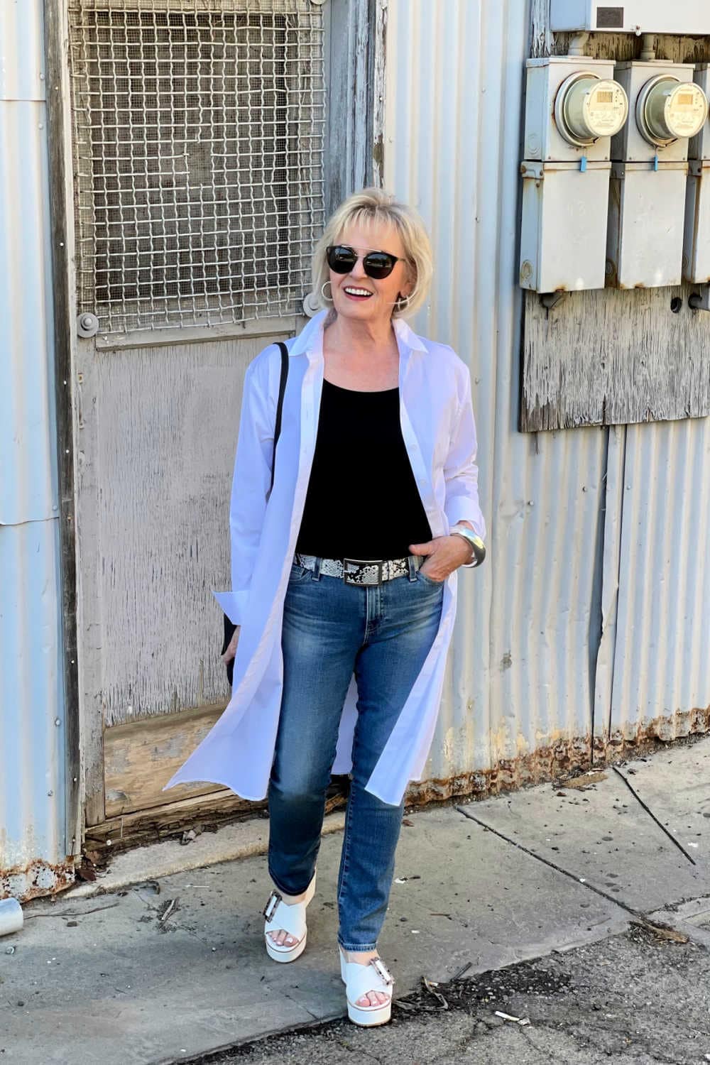 woman walking in poplin shirtdress blue jeans and platform sandals