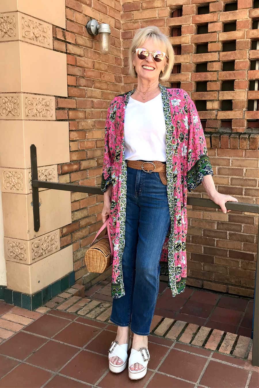 blonde blogger wearing pink kimono with blue jeans and white wedge sandals
