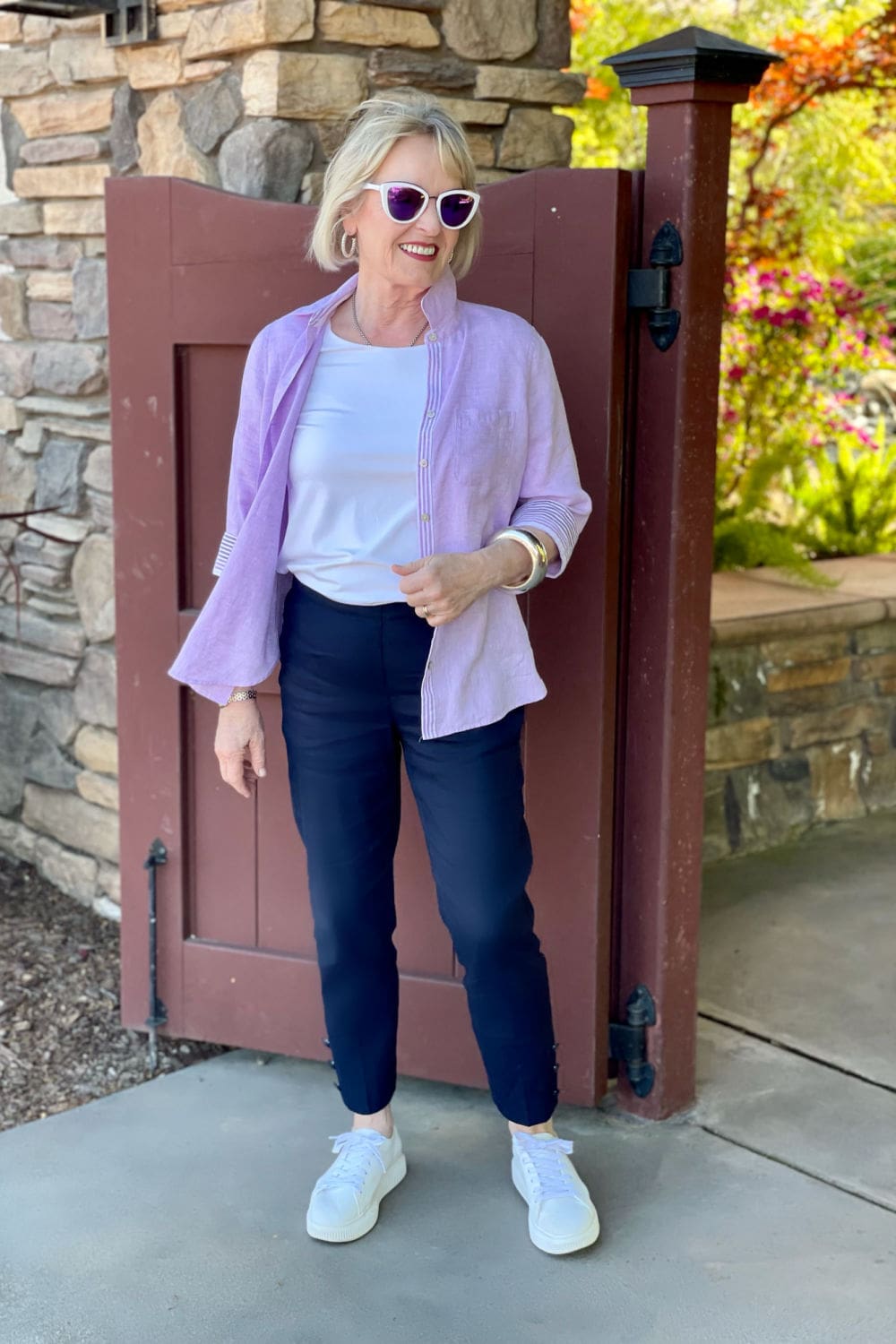 jennifer of a well styled life wearing linen shirt, linen pants and white sneakers with purple sunglasses