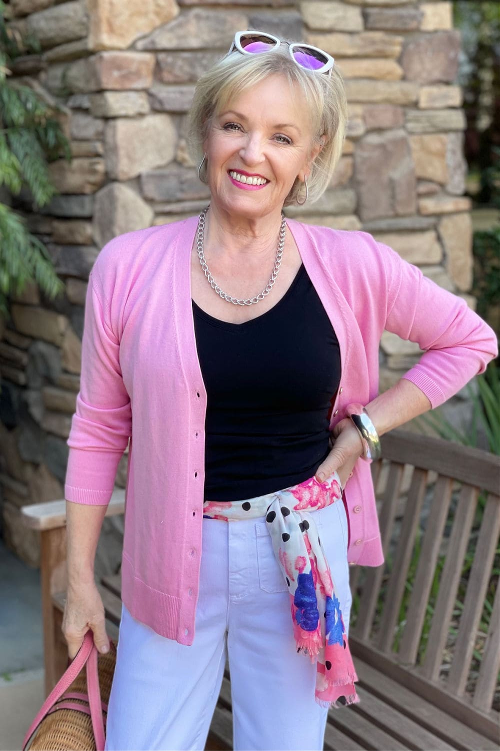 woman wearing scarf as belt with pink sweater and white pants