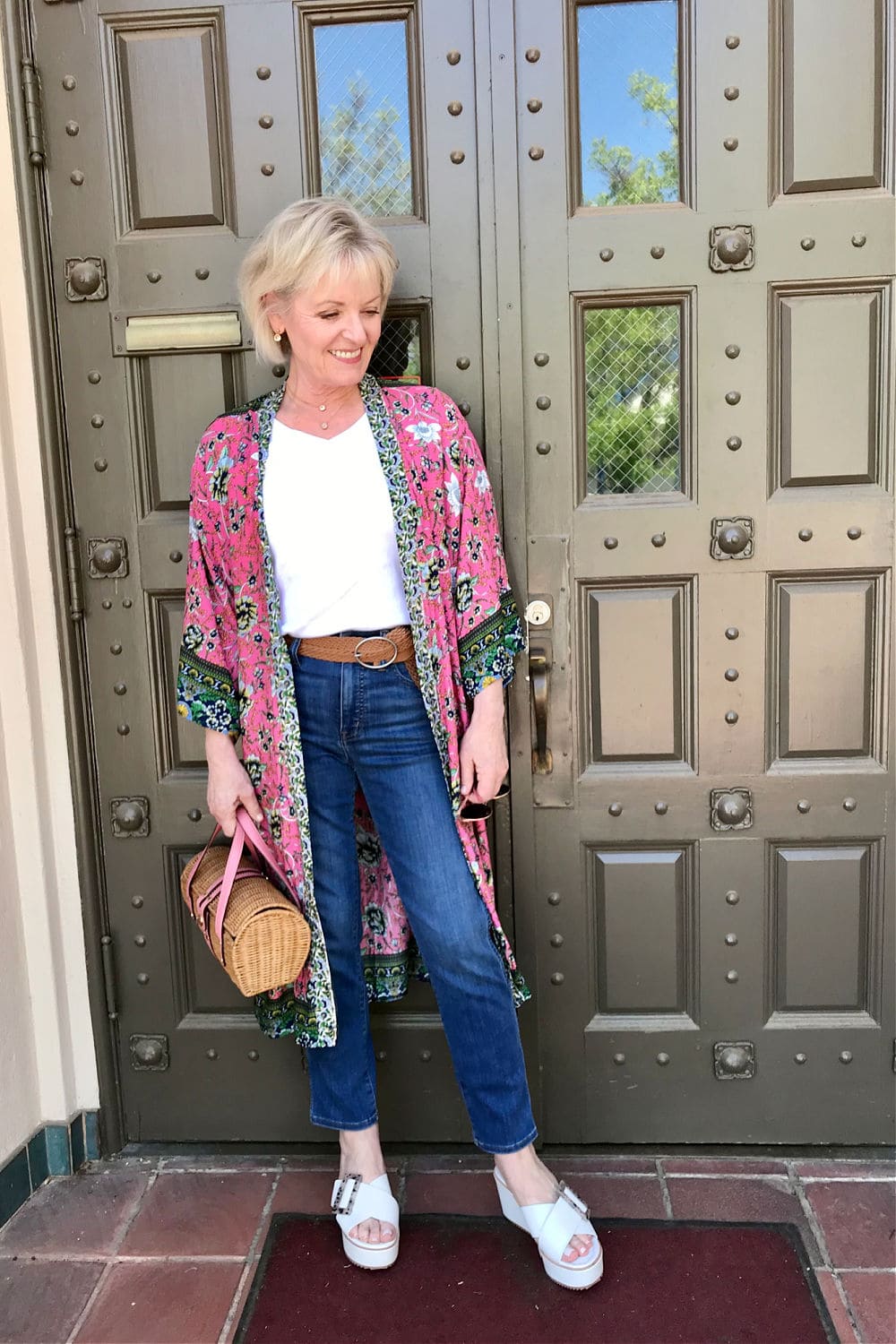 blonde woman wearing pink kimono ovr white tee and blue jeans