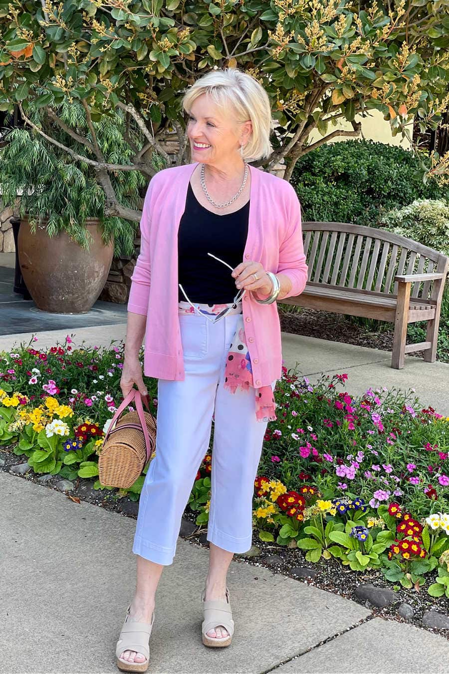 woman wearing pink cardrigan over white crop chinos
